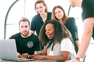 diverse start up team looking at a single laptop